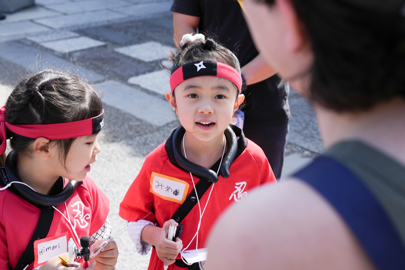 忍者衣装で外国人観光客に英語インタビューをする子どもたち