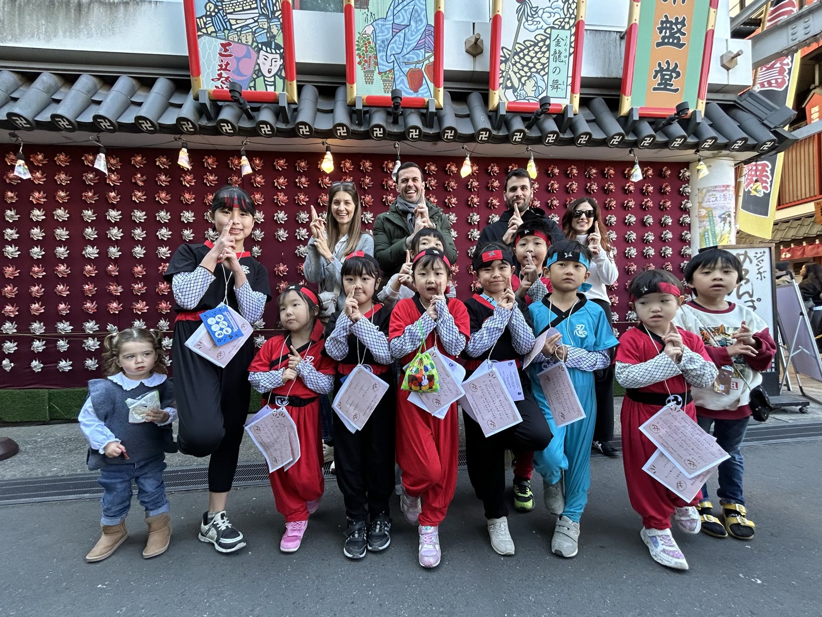浅草で外国人観光客と一緒に集合写真を撮る忍者衣装の子どもたち